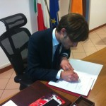 Il Presidente mentre appone la sua firma